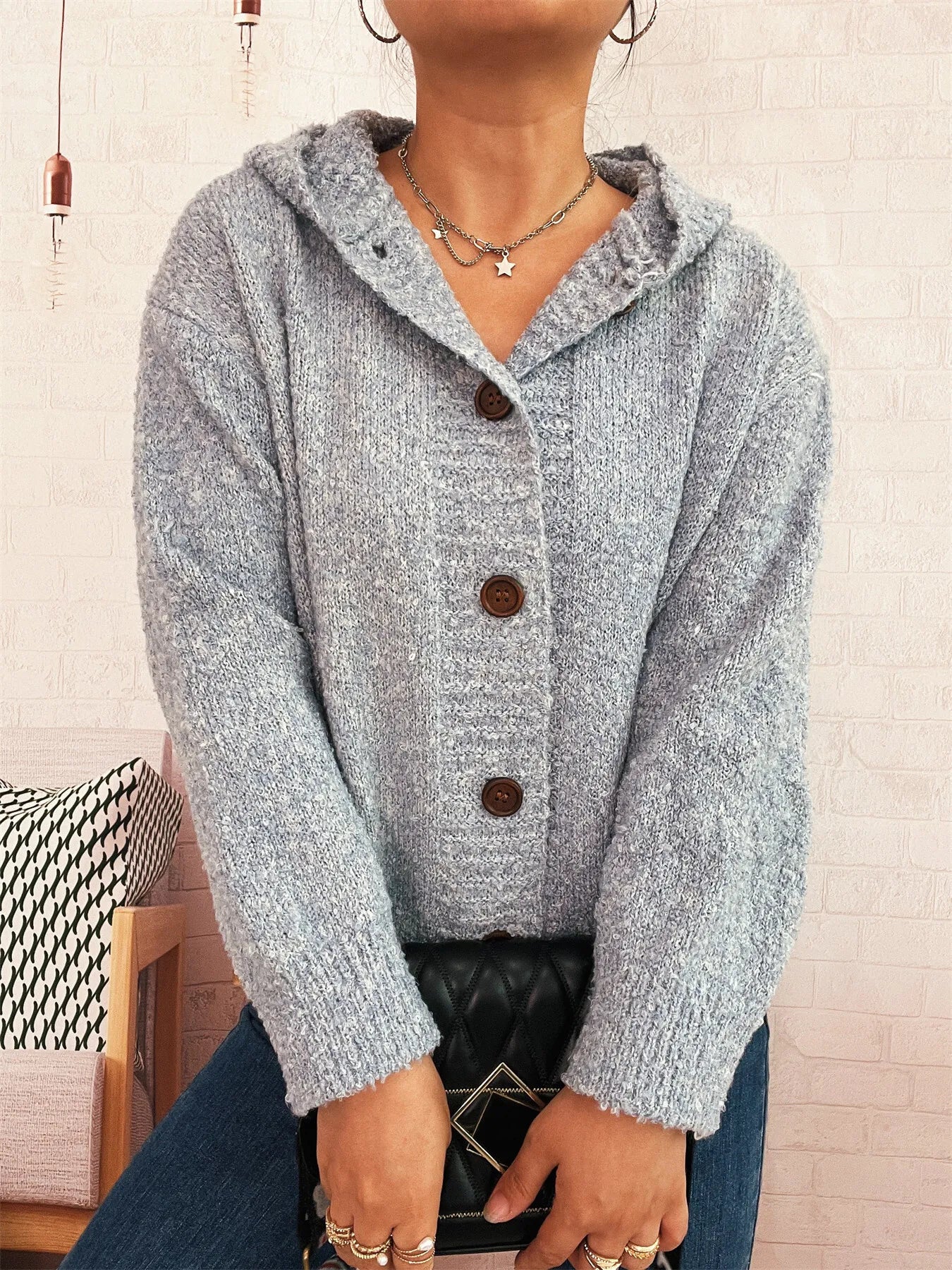 Cozy hooded cardigan, heather gray knit with brown buttons and long sleeves.