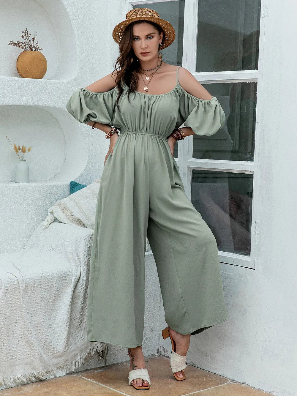 Sage green wide-leg jumpsuit with spaghetti straps, gathered waist, and cold-shoulder puff sleeves