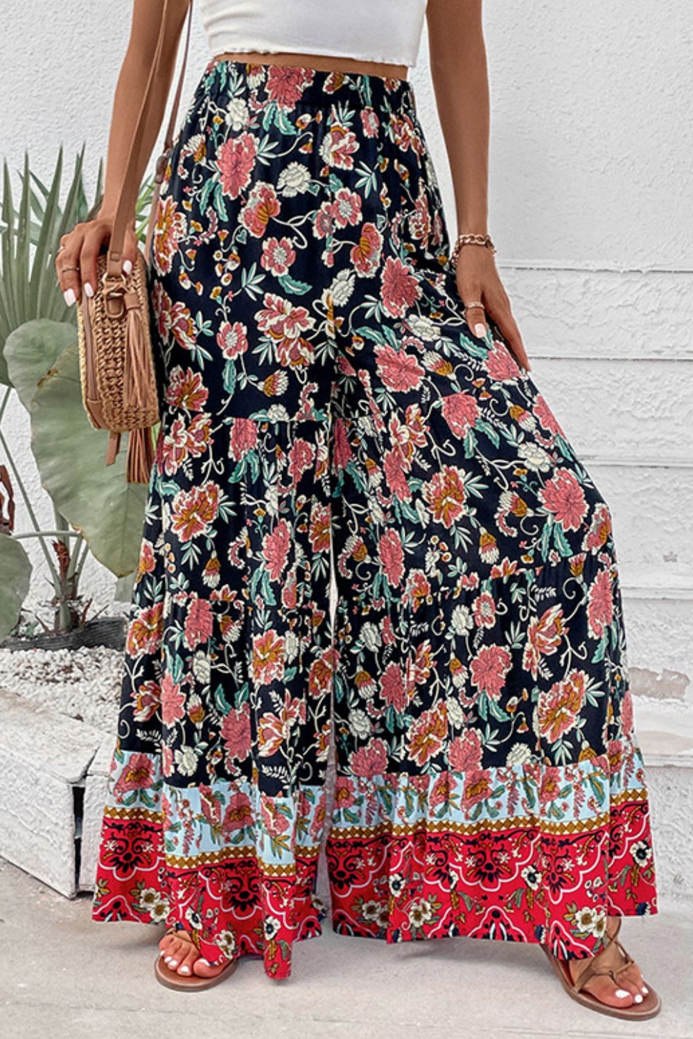 Floral high-waist palazzo pants with tiered skirt panels and red patterned hem trim