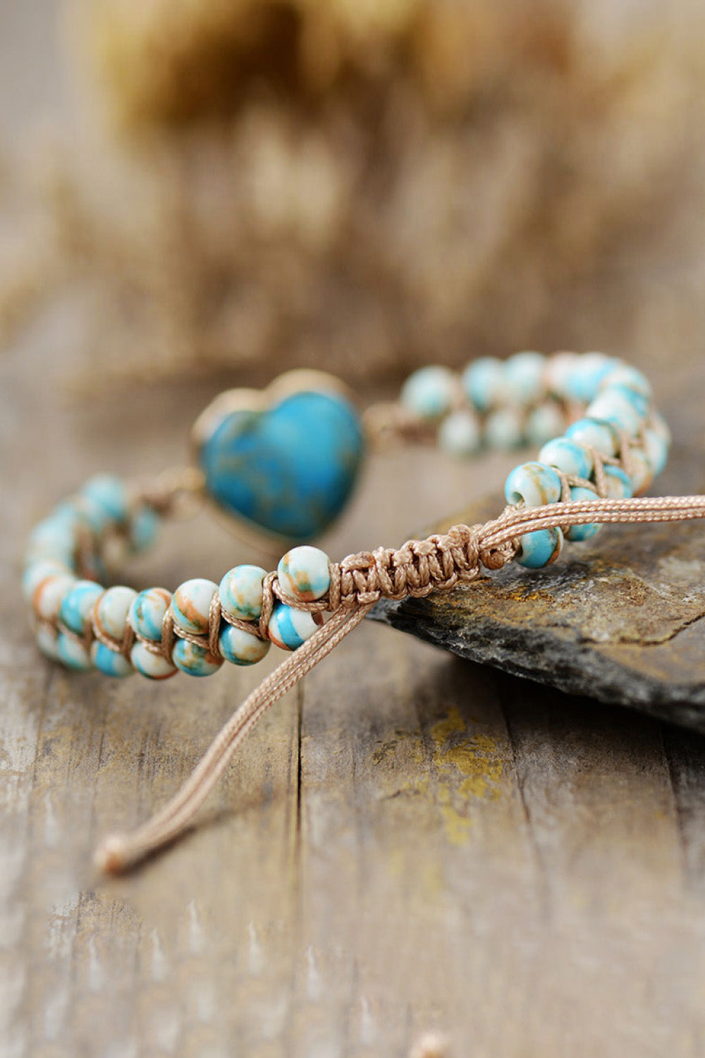 Blue beaded heart bracelet with heart charm, braided cord, and tied adjustable ends
