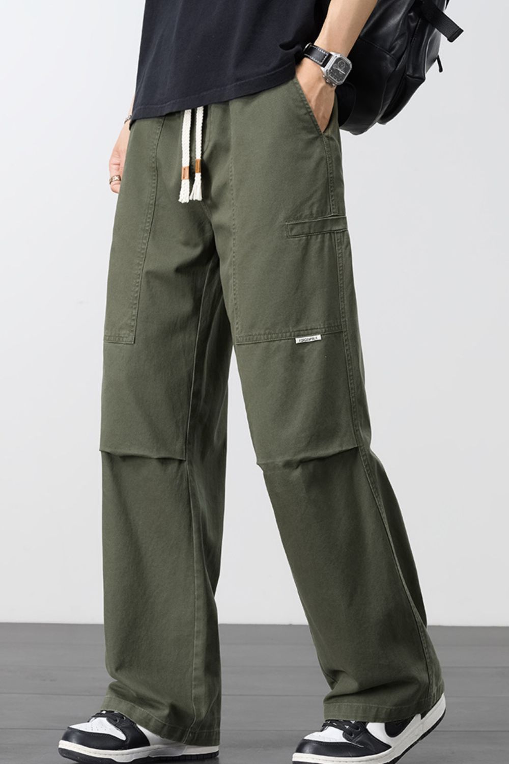 Army green loose cargo pants with drawstring waist and large side cargo pockets.