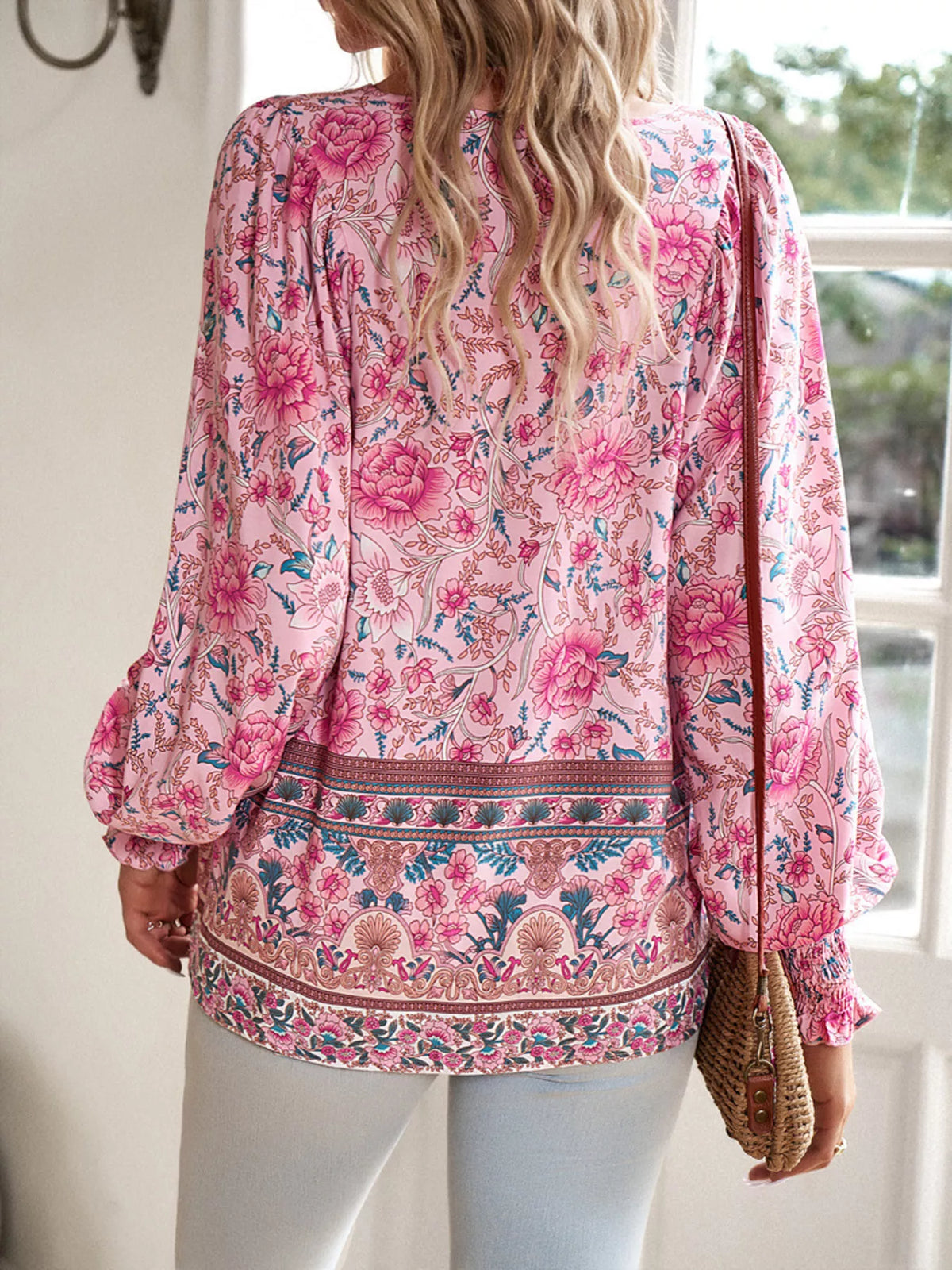 Pink floral blouse back view with long sleeves and smocked cuff detailing