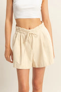 High-waisted paperbag shorts in oatmeal, with drawstring tie and pleated front