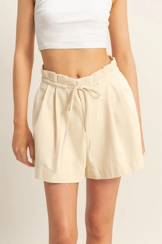 High-waisted paperbag shorts in oatmeal, with drawstring tie and pleated front