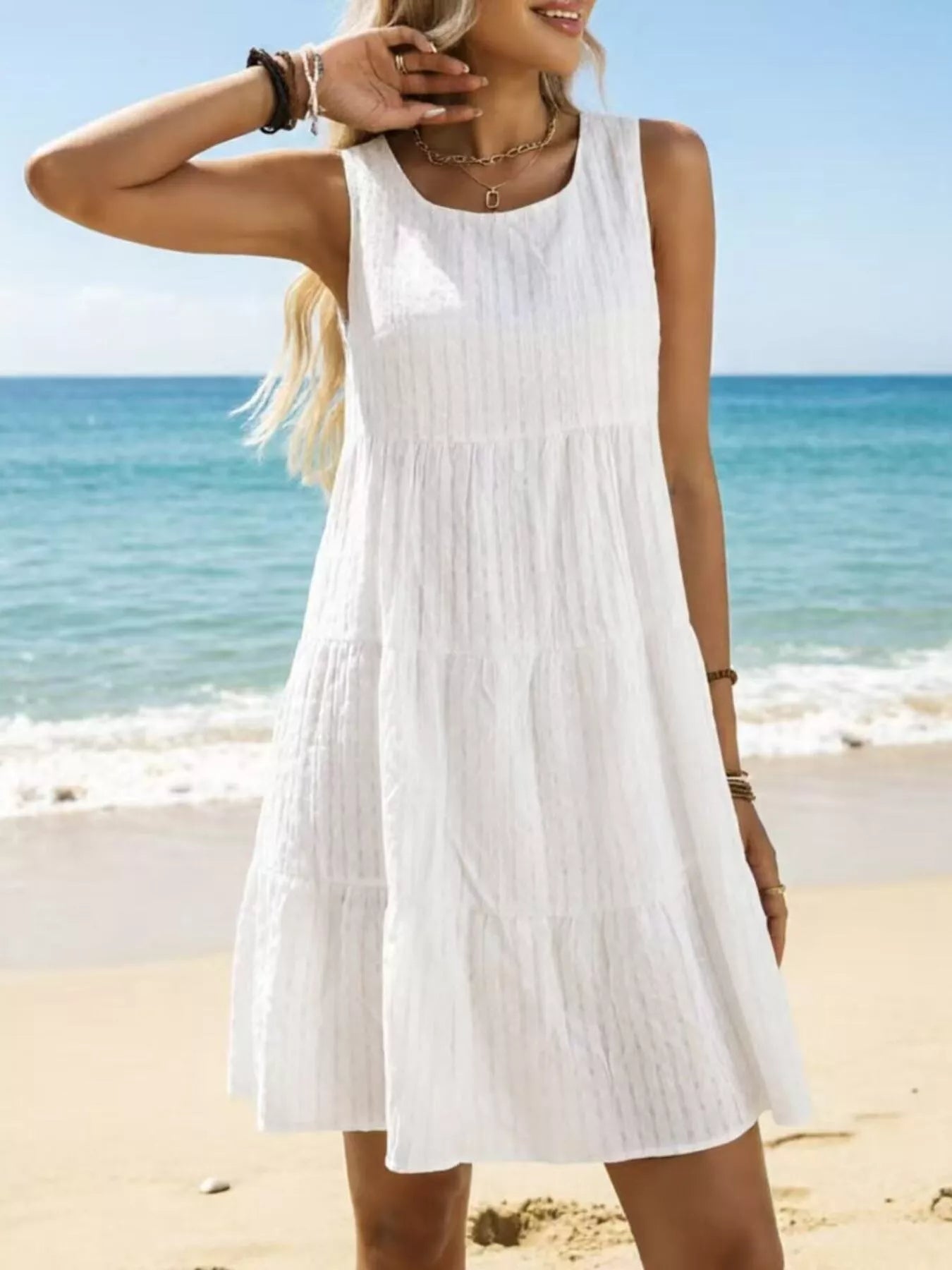 White sleeveless tiered mini dress with gathered bodice and round neckline