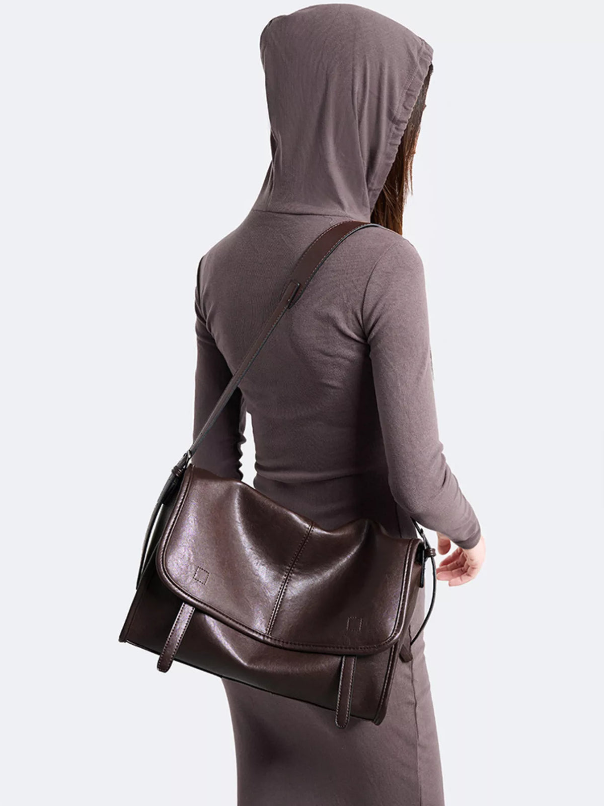 Back view of brown messenger bag with adjustable strap and flap-over back panel