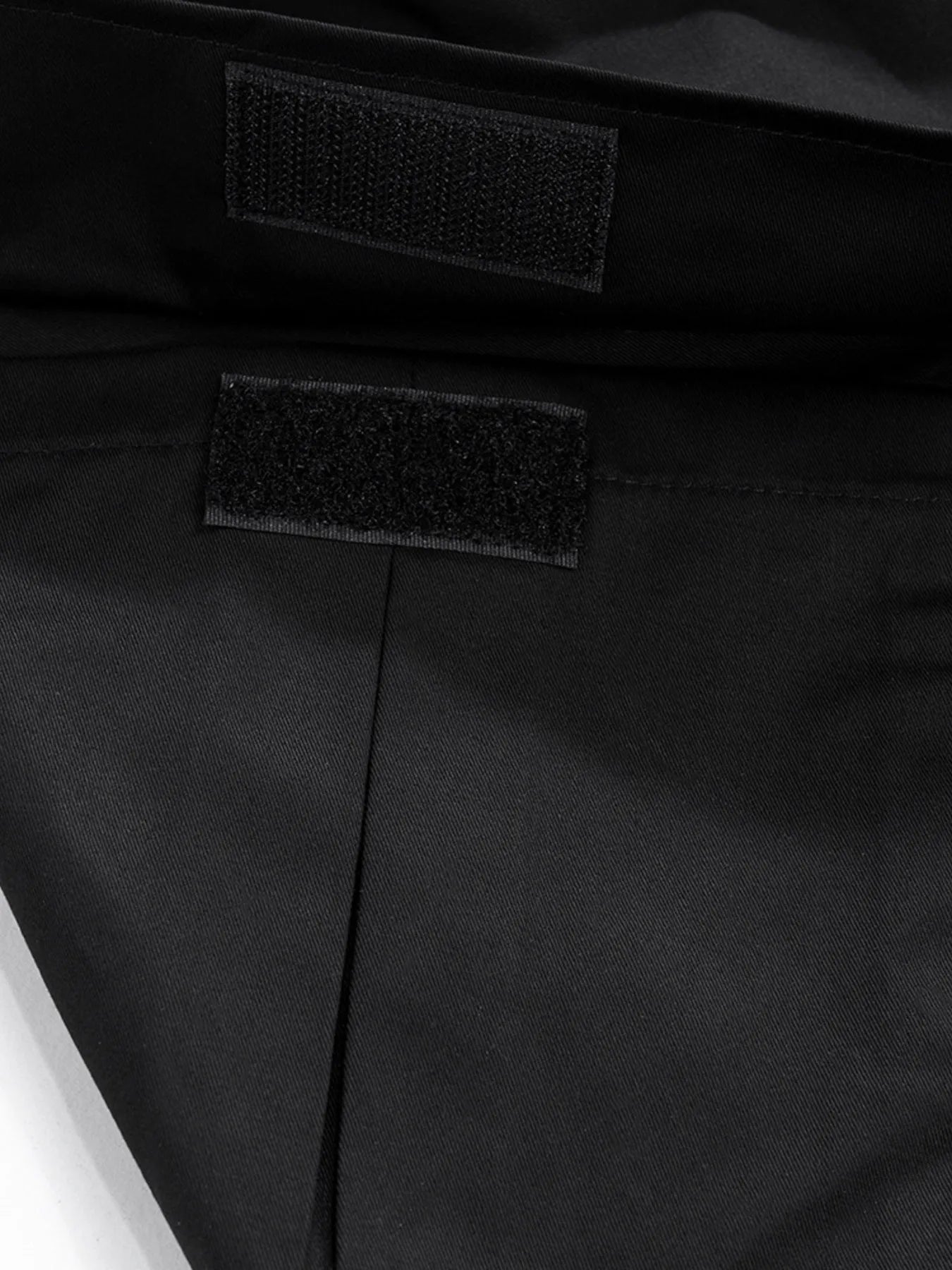 Black cargo pants inner patch label near waistband, close-up.
