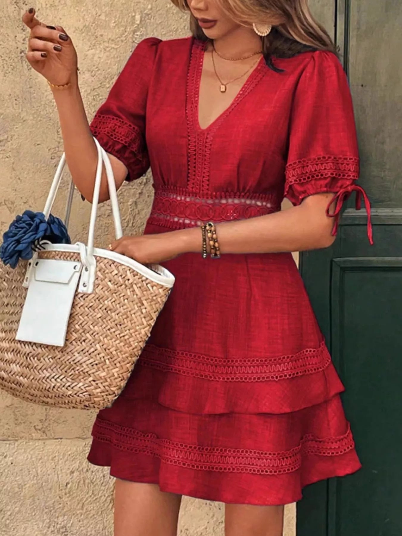 Red V-neck mini dress with lace trim, tiered skirt, and bow-tied sleeves