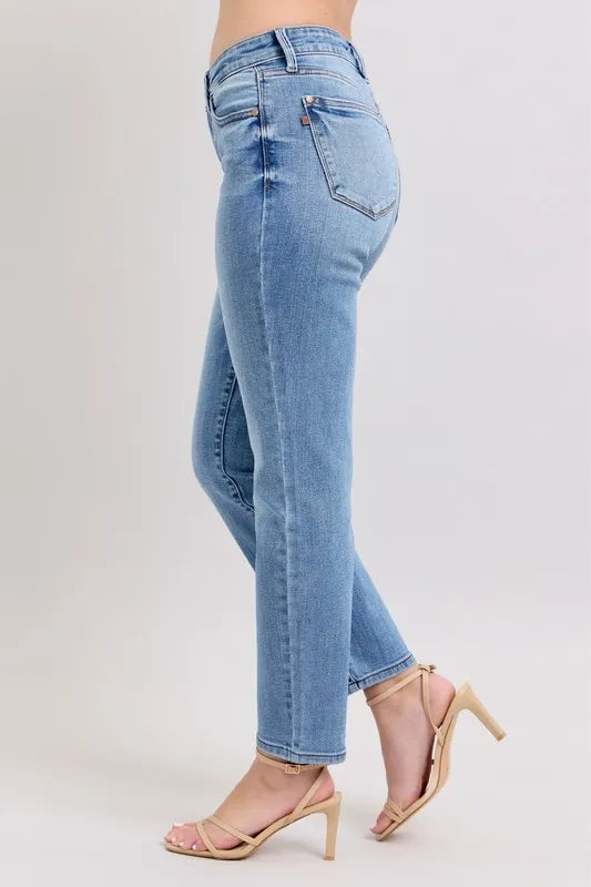 Light blue mid-rise slim jeans from a side back angle with rear pocket and cropped hem