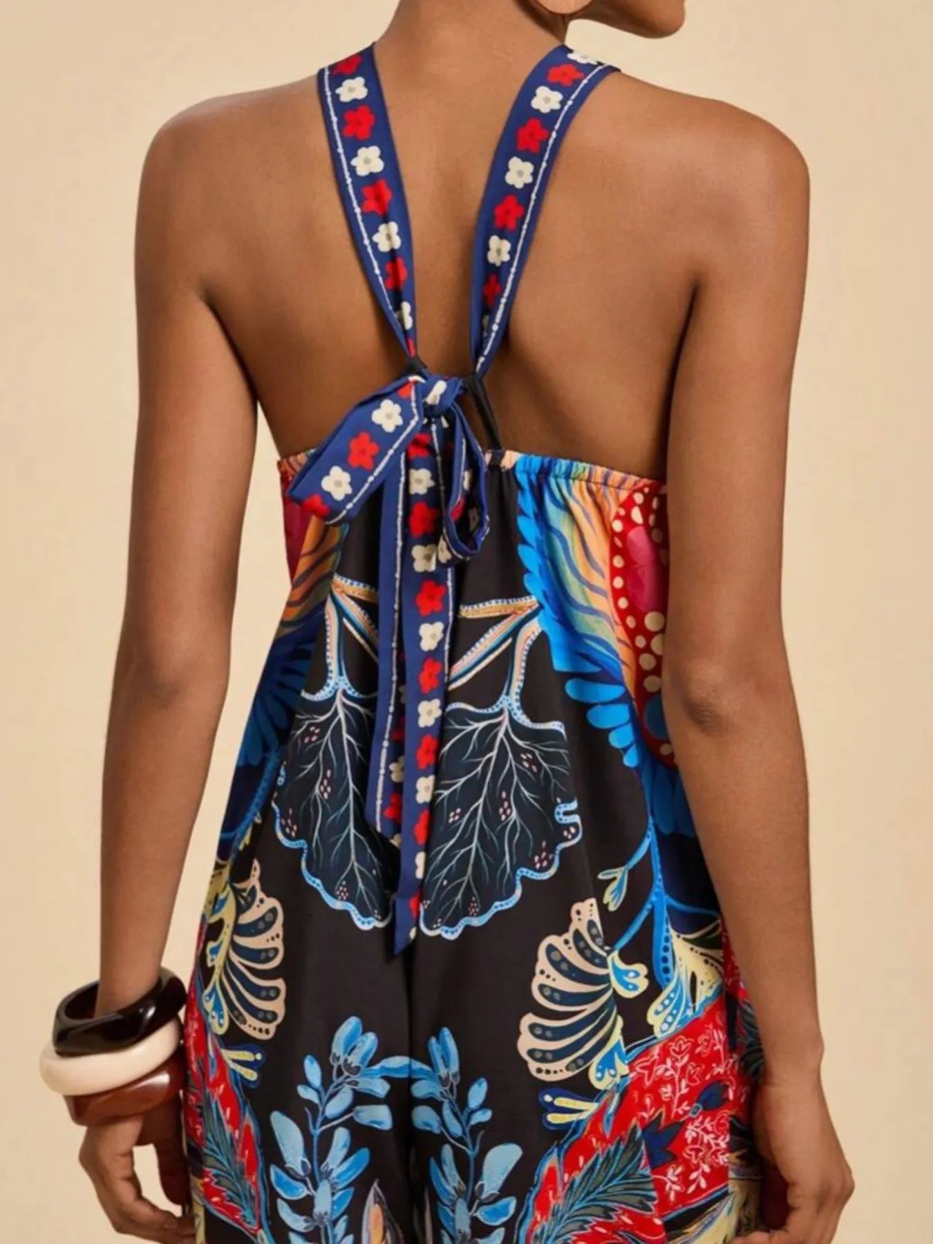 Black halter wide-leg jumpsuit with open back tie and tropical floral print