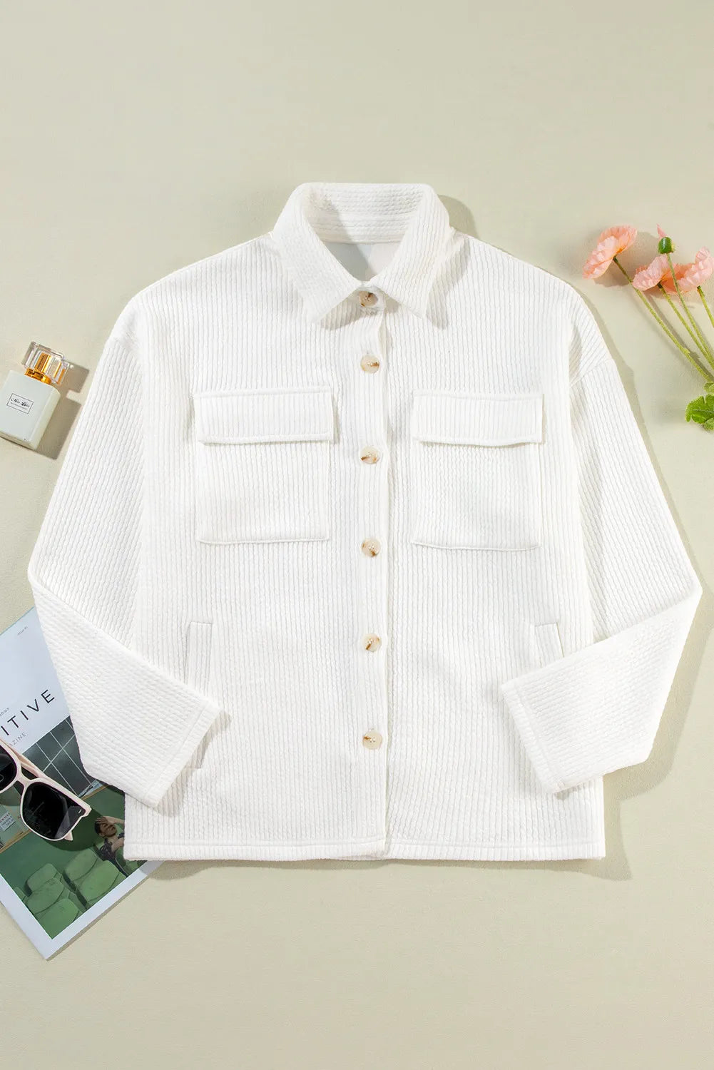 White long-sleeve shacket with button front and two flap chest pockets, laid flat.