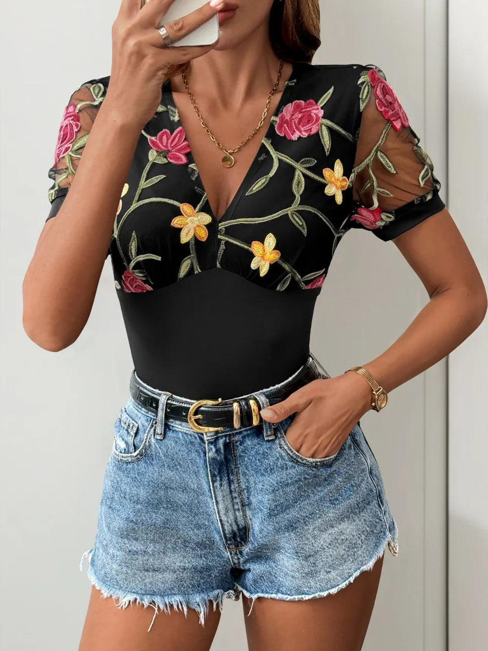 Black embroidered floral V-neck bodysuit with sheer puff sleeves and fitted waist