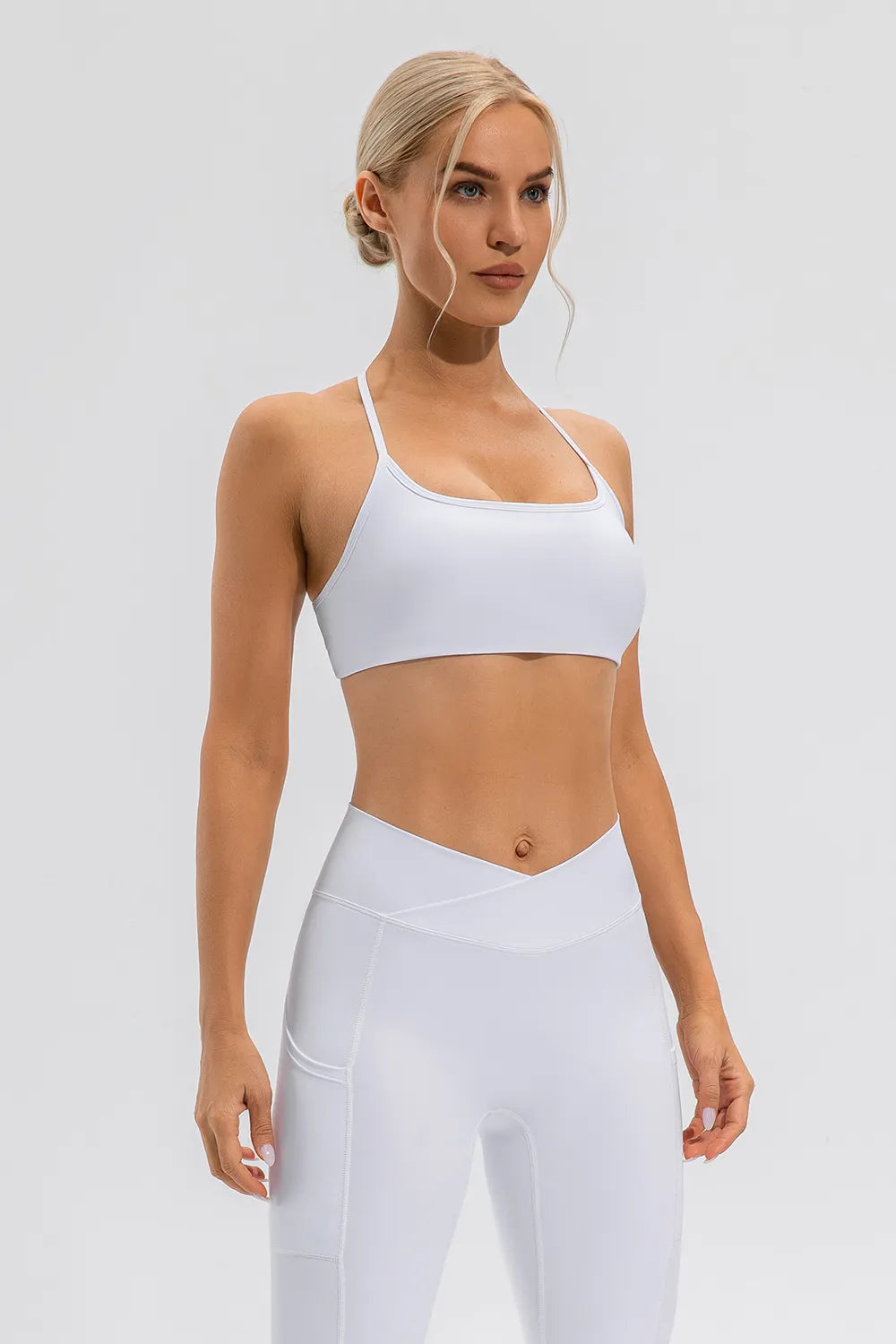 White active crisscross spaghetti strap cami with straight neckline and cropped length