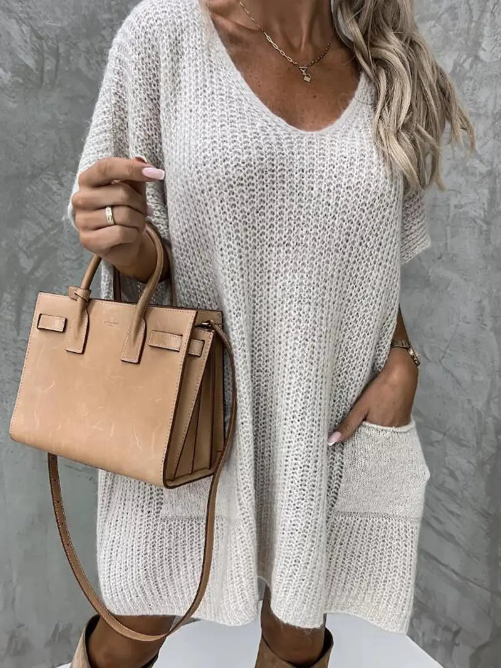 White V-neck short-sleeve knit sweater with front pocket and extended tunic hem.