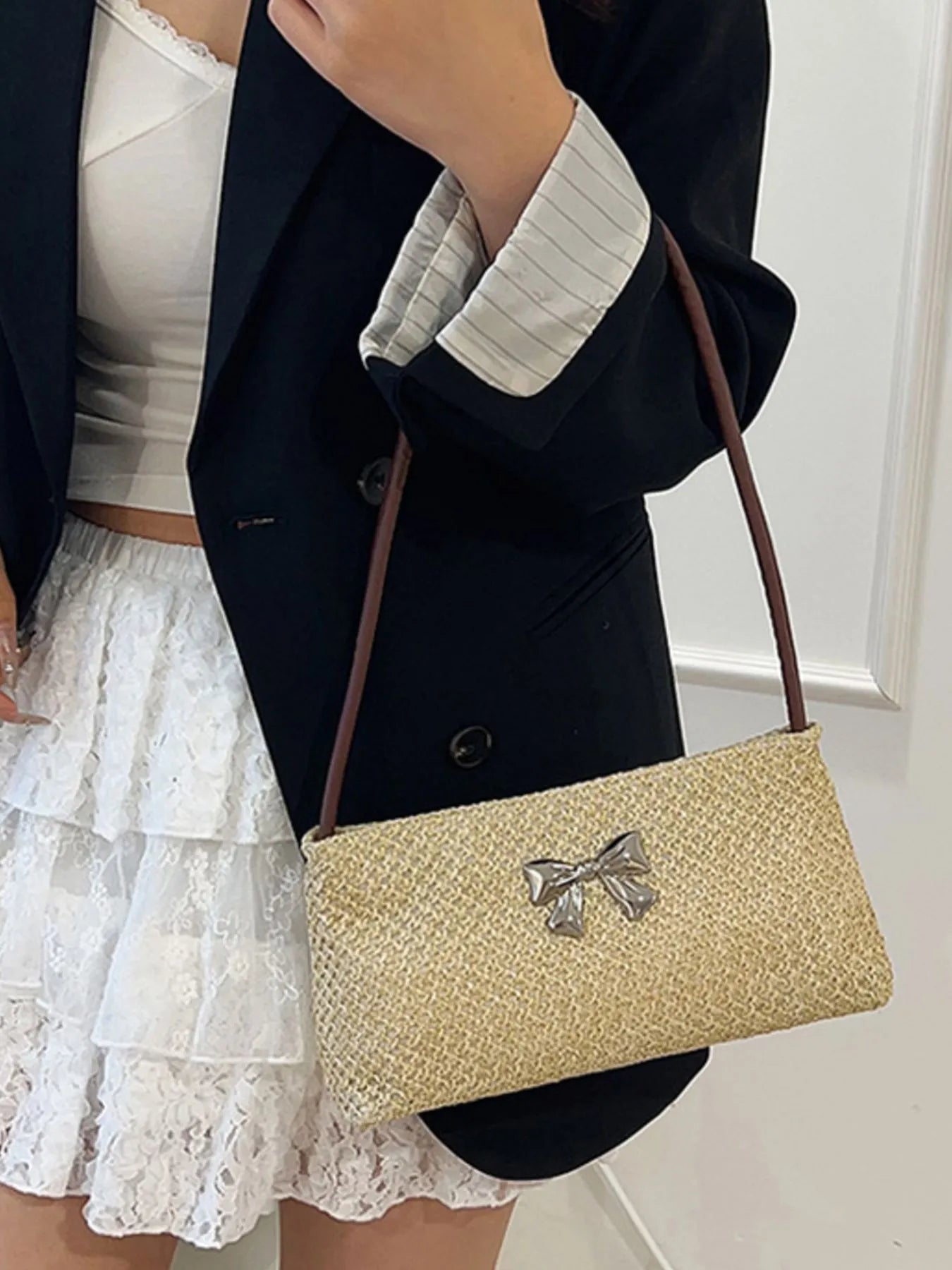 Woven straw shoulder bag with silver bow appliqué and brown crossbody strap
