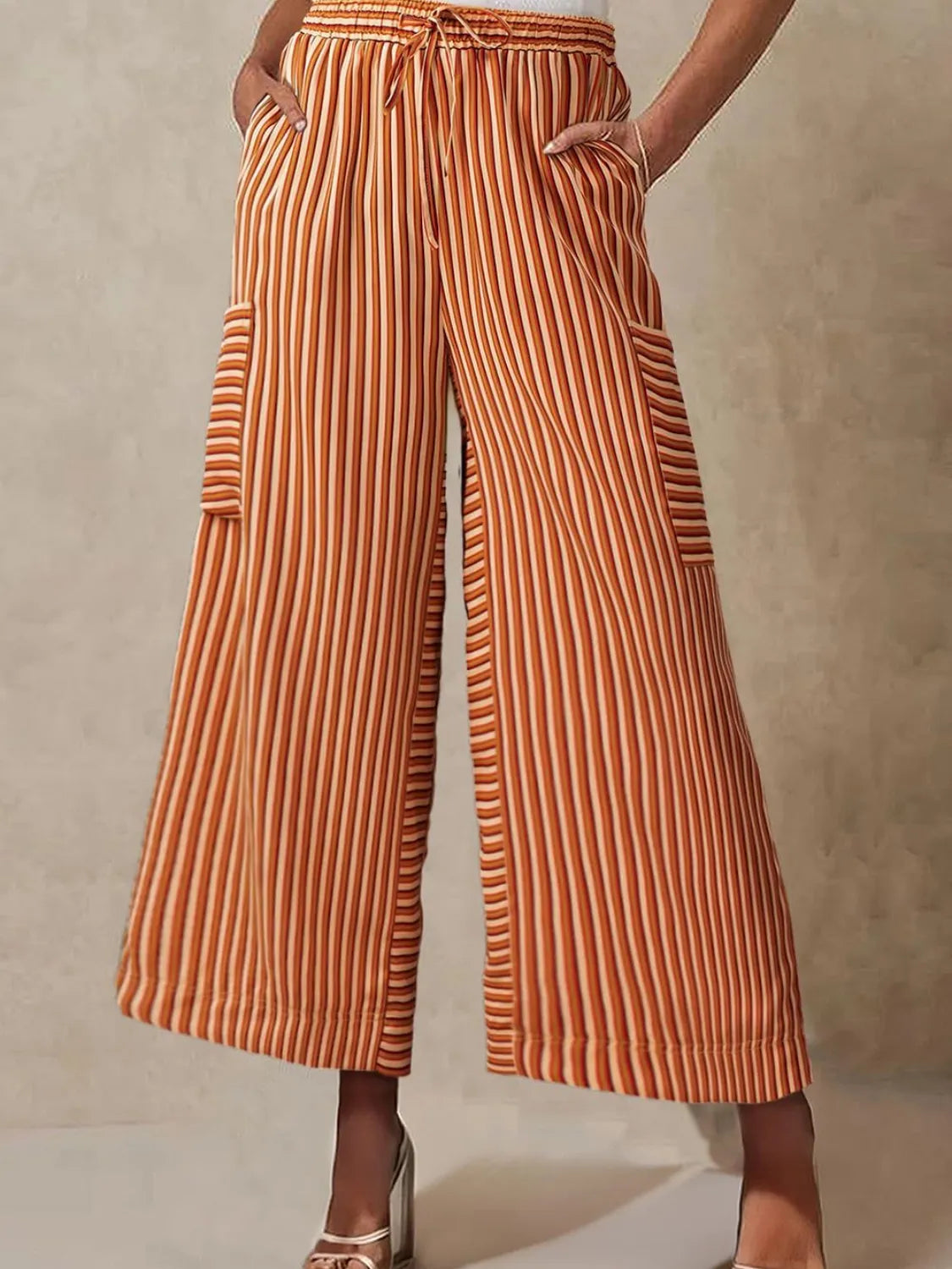 Orange striped wide-leg pants with elastic drawstring waist and side patch pockets