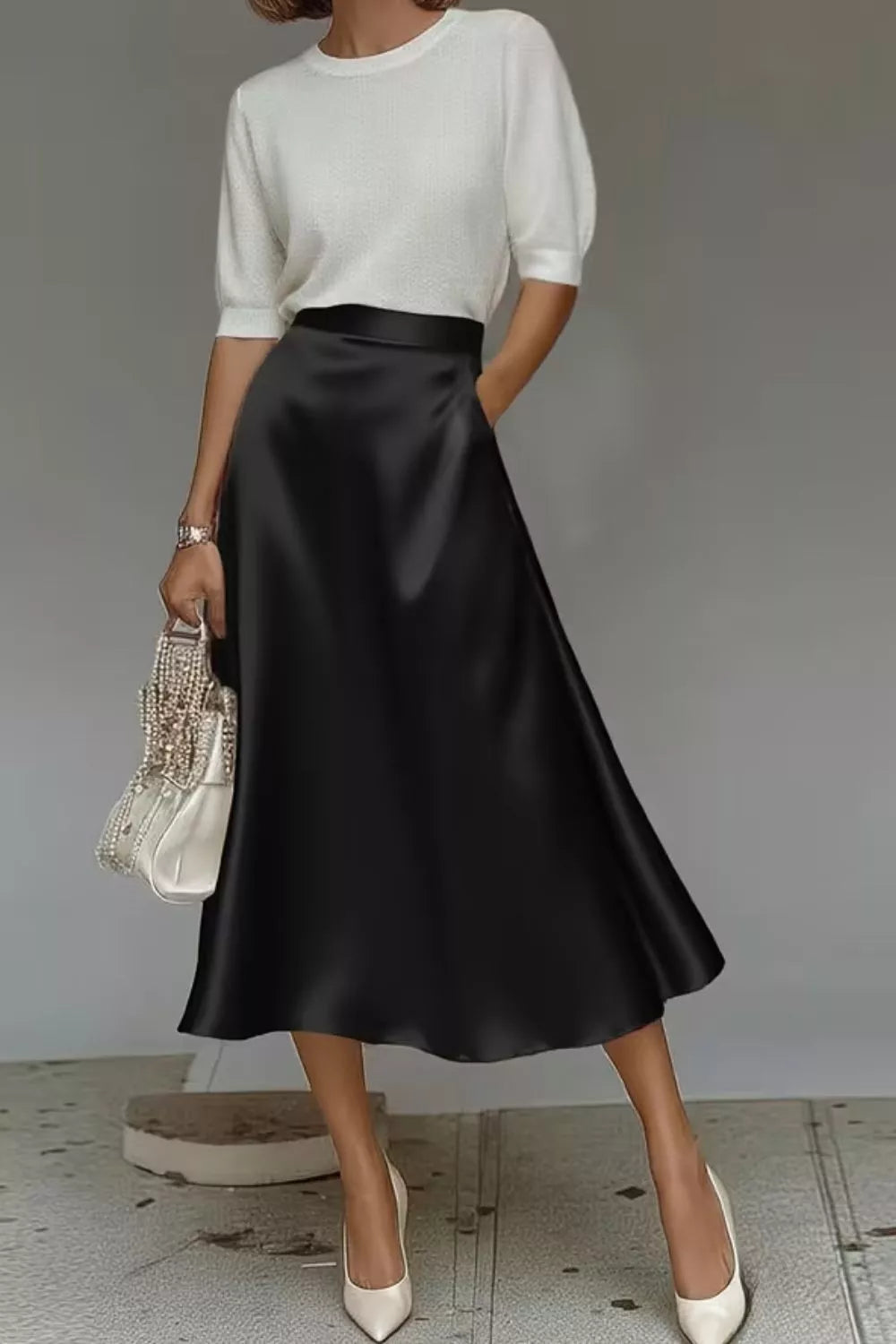 Black satin A-line midi skirt with side pockets, glossy drape and mid-calf length