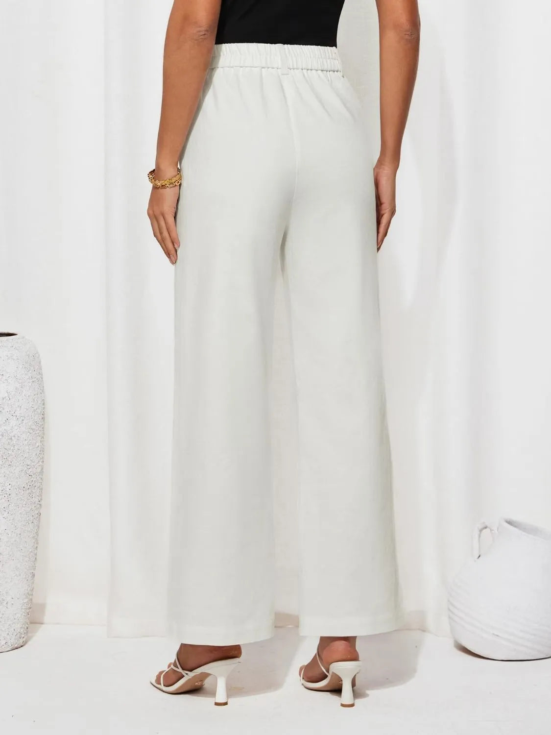 White high-waist wide-leg pants with elastic back waistband and relaxed wide legs