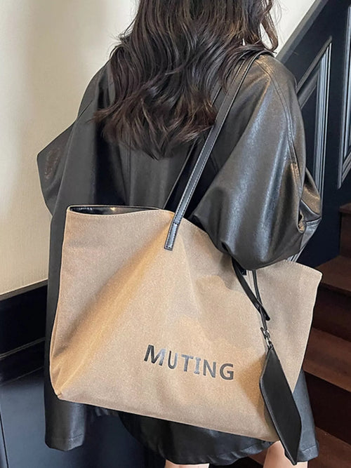 Tan canvas tote shoulder bag with black trim, top drawstring, and front “MUTING” print