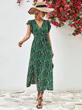 Green printed surplice neck flutter sleeve slit dress, midi length with fitted waist and V neckline.