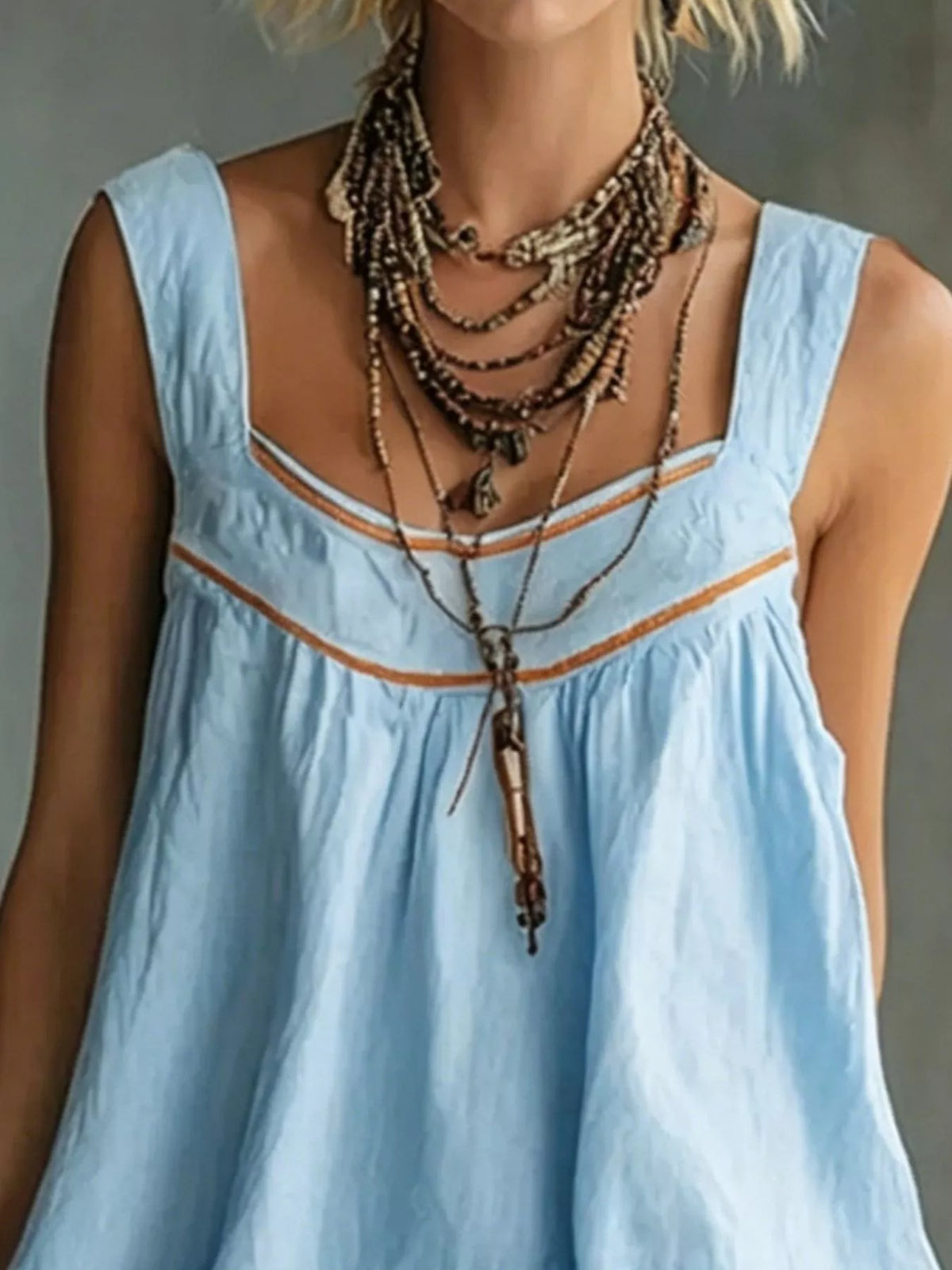 Light blue sleeveless mini dress with orange trim, square neckline, and tiered ruffles