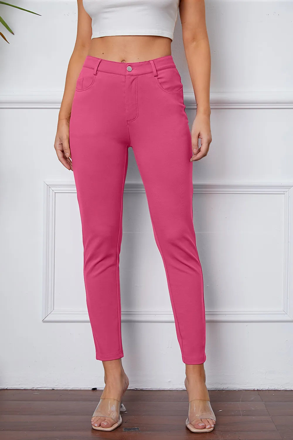 Stretchy pink pants with button waistband and slim ankle-length tapered leg