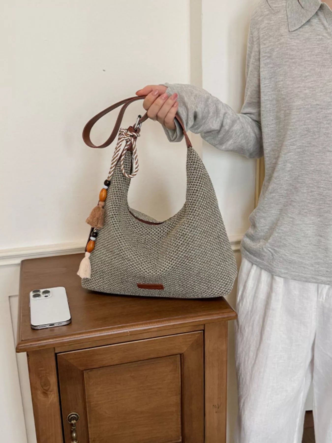 Medium woven shoulder bag with tassel fringe, brown leather handles and textured gray body