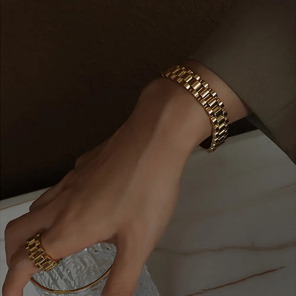 Gold chain bracelet with rectangular links, worn on wrist