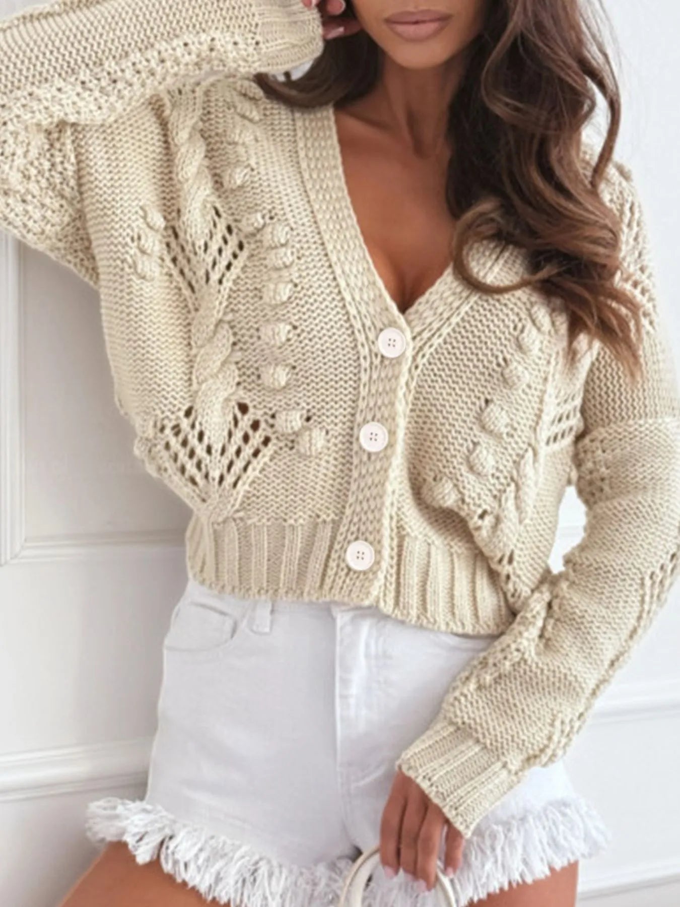 Beige cropped button-up sweater cardigan with cable knit texture and button front