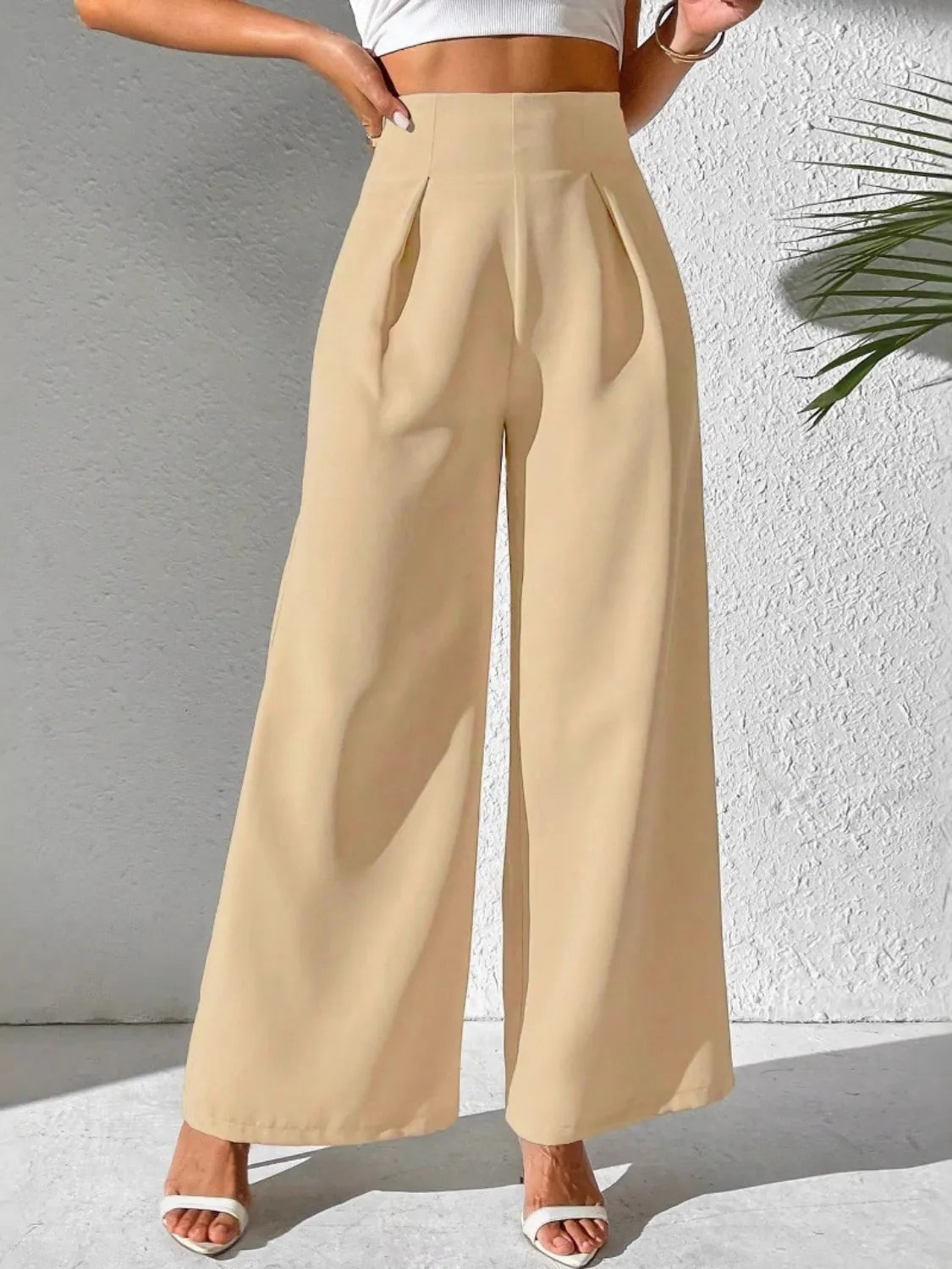 Light tan wide-leg high-waist pants with pleated front and wide hems