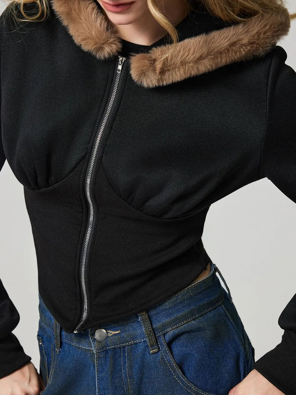 Black hooded zip-up jacket with fuzzy collar trim and long sleeves, front zipper detail.