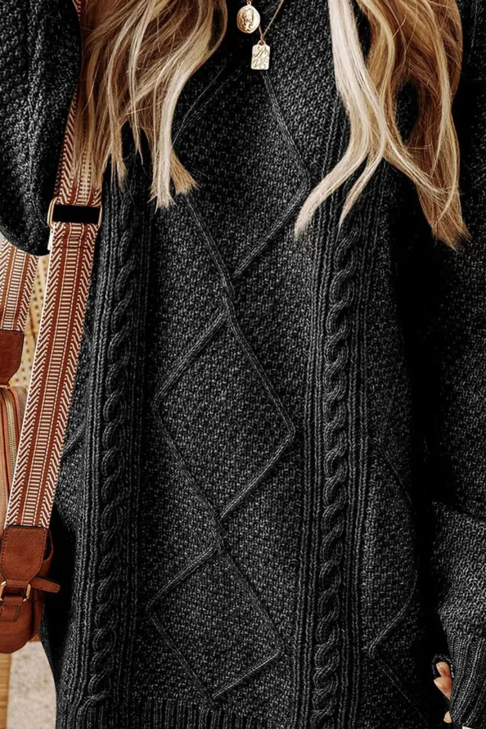 Black cable-knit sweater dress close-up with diamond knit and raised rope cables