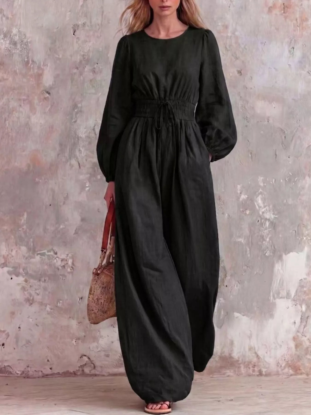 Smocked waist long-sleeve jumpsuit in black with gathered waist and wide legs