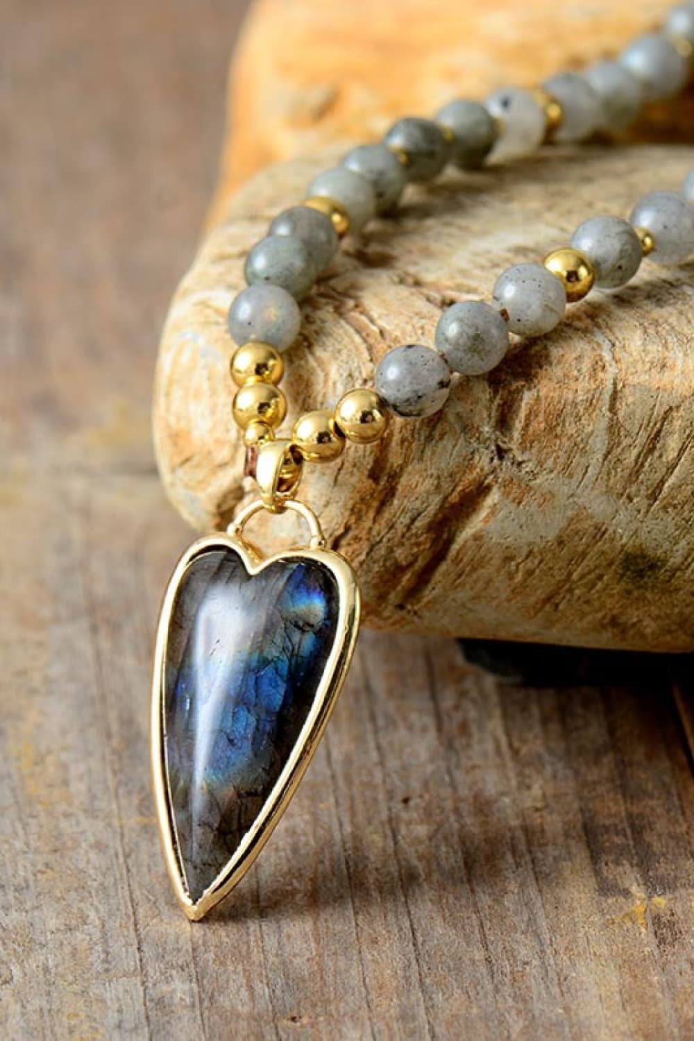 Beaded necklace close-up with teardrop blue stone pendant and blue-gray beads