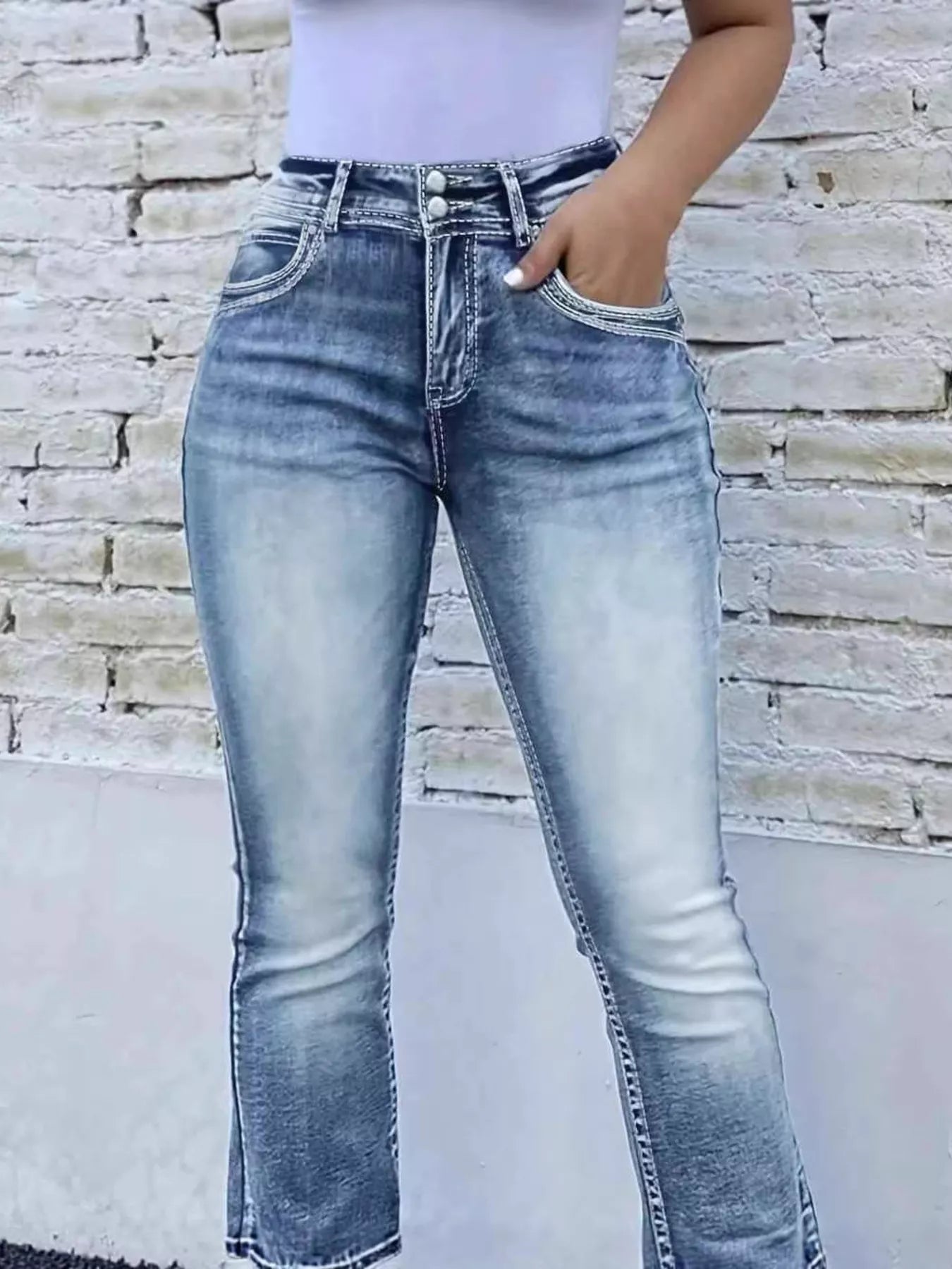 High-waist bootcut jeans with light blue denim wash, stitched seams, and front pockets