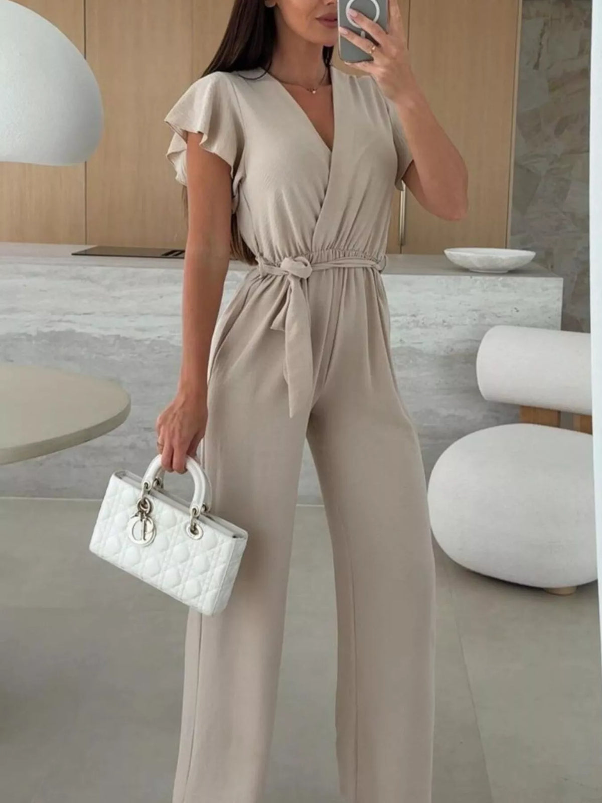 Beige surplice wide-leg jumpsuit with short ruffle sleeves and tie waist