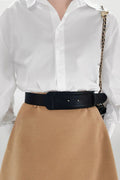 Vegan leather belt in dark color, wide strap with silver buckle holes and pin hardware