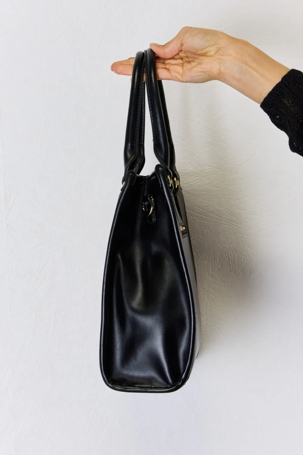 Black PU leather handbag with top handles, smooth finish and gold-tone hardware