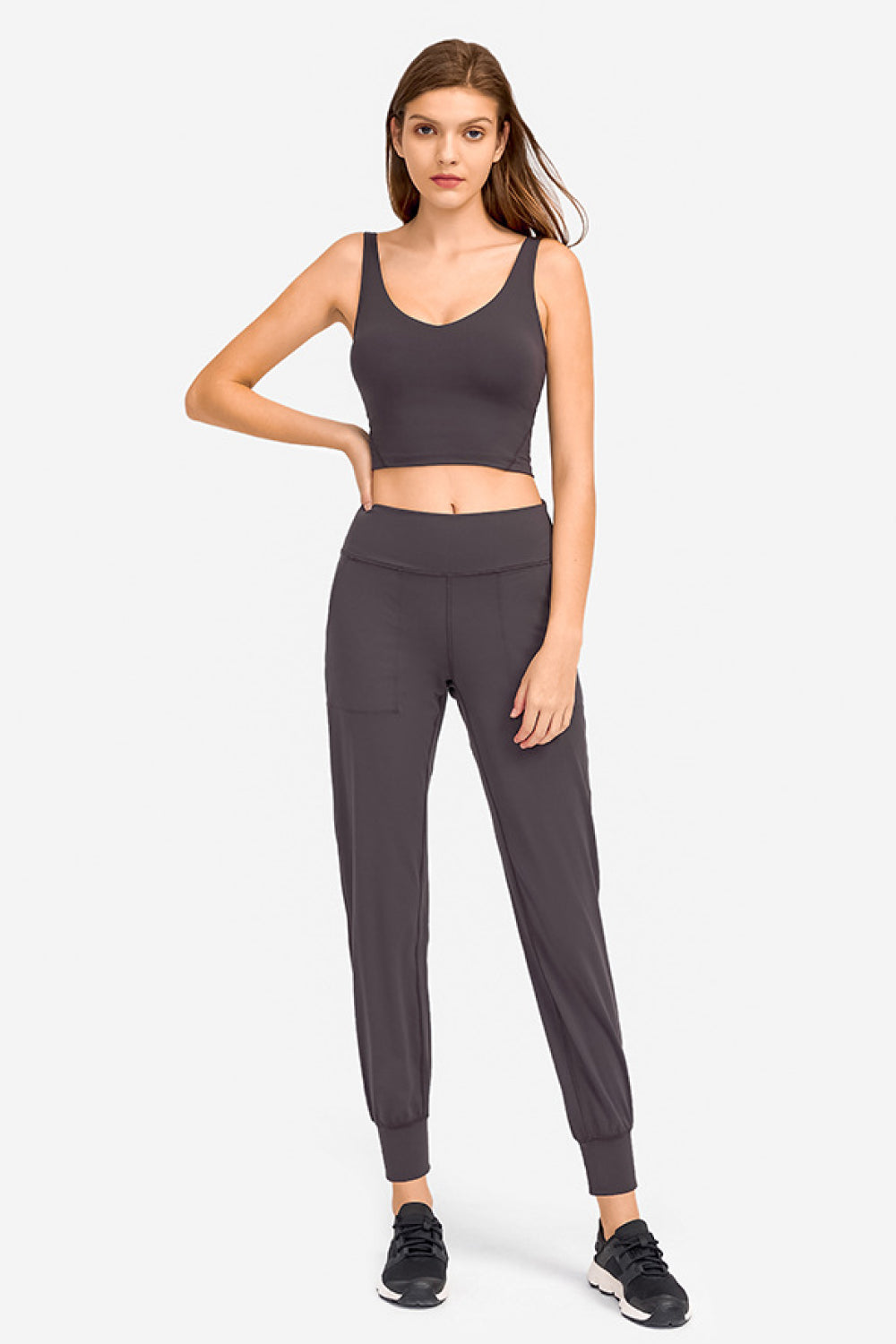 Deep V-neck crop sports bra, dark gray-black color, front view.