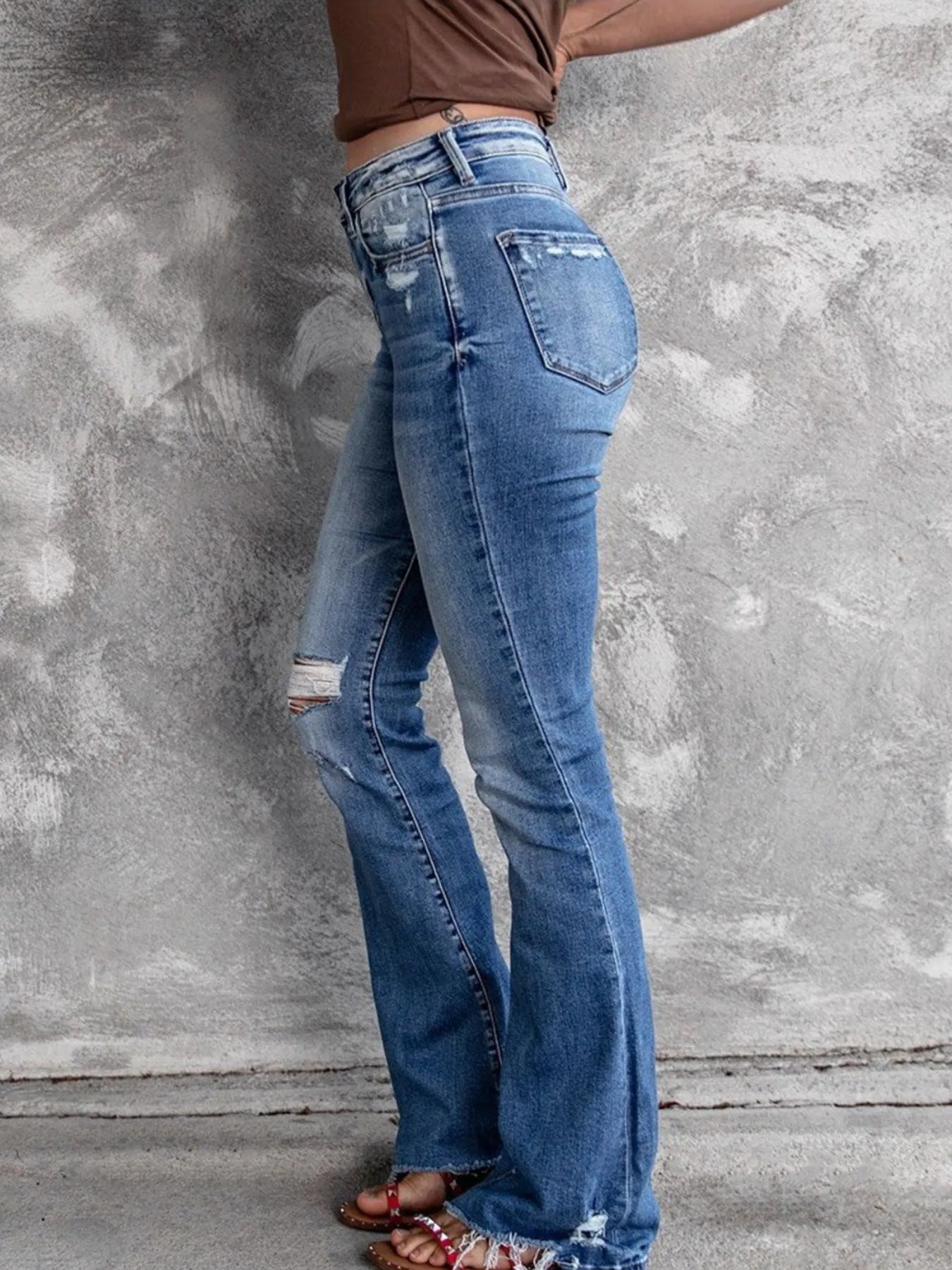 Light blue distressed flare jeans with back pocket distress and flared hems