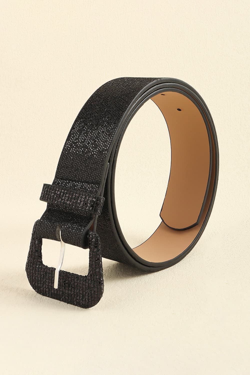 Black glitter vegan leather belt with buckle and punched end, angled view