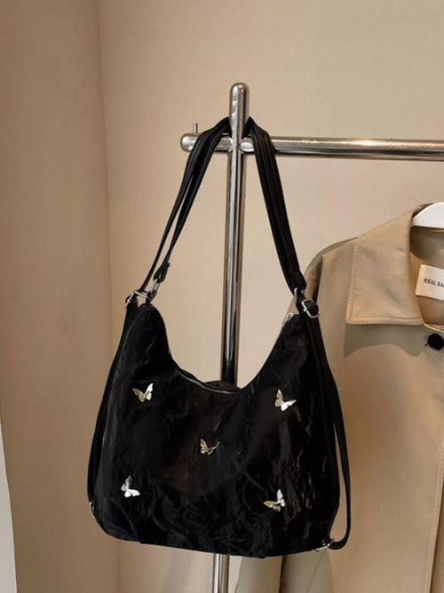 Black hobo shoulder bag with butterfly appliques and dual shoulder straps