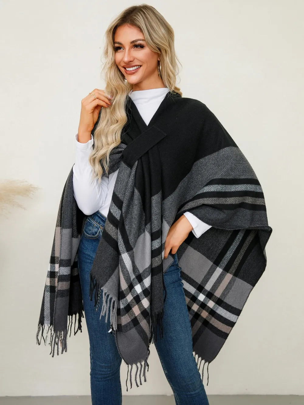 Plaid contrast poncho with fringe trim in black and gray windowpane checks