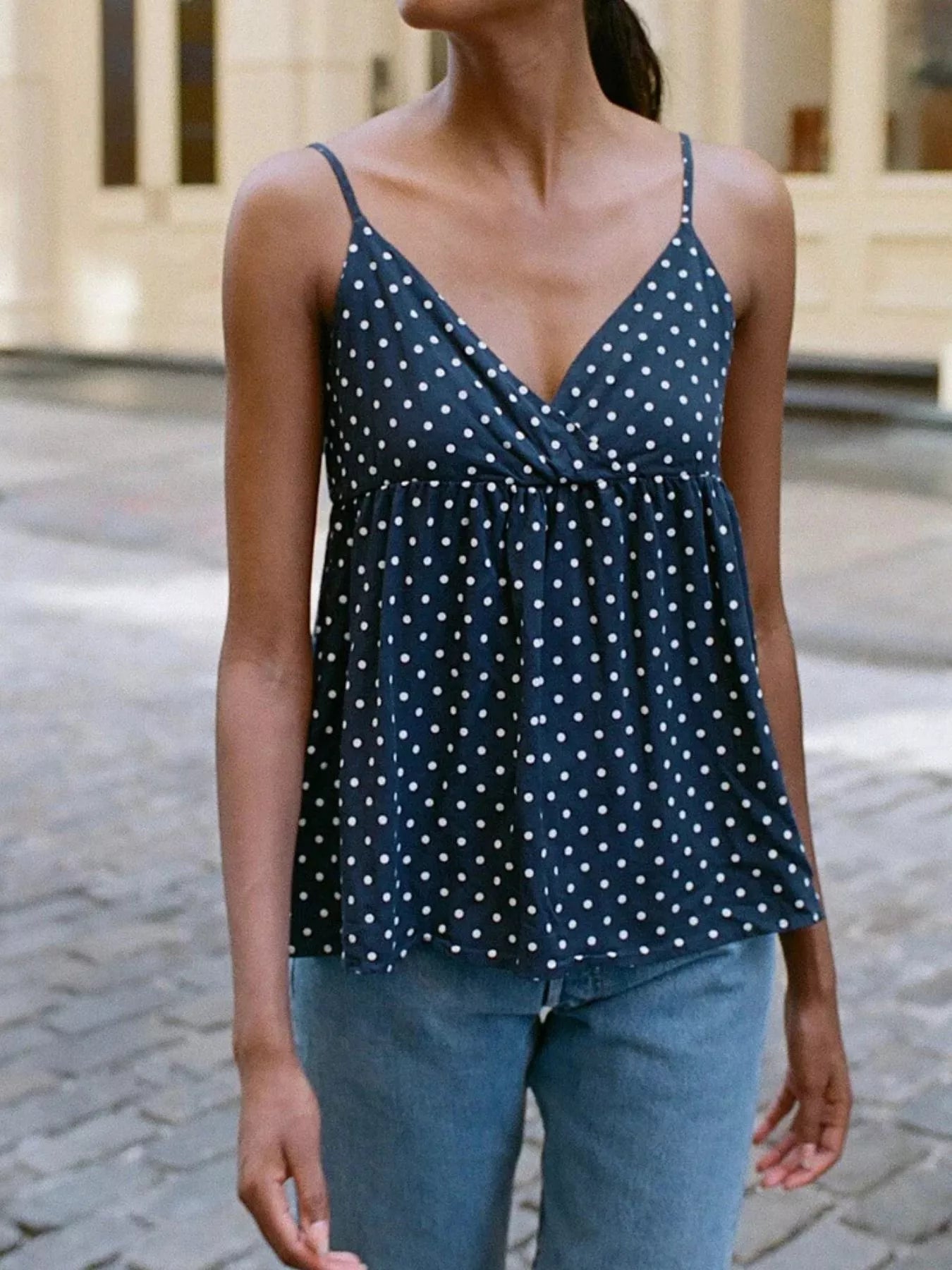 Dark blue polka dot V-neck flowy cami with thin spaghetti straps and gathered bust