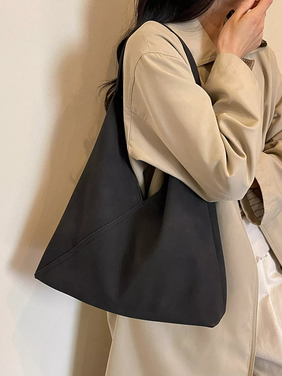 Black slouchy suede shoulder bag, front angled view with wide strap