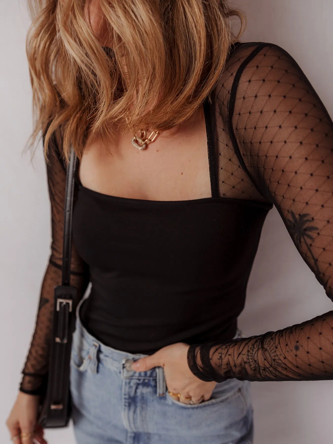 Black mesh sleeve square-neck bodysuit with sheer dotted sleeves and scoop-back style