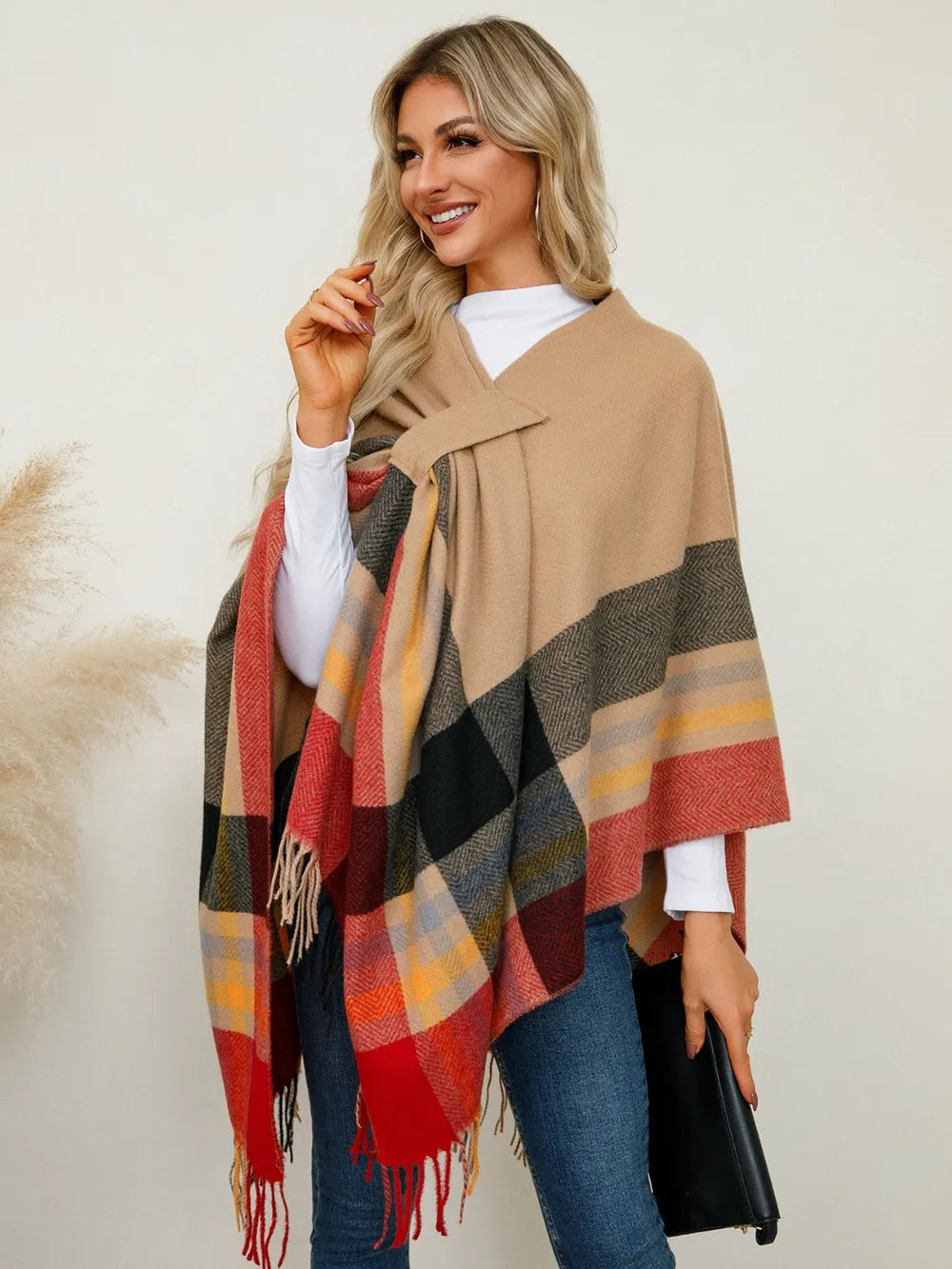 Plaid contrast poncho with fringe hem in tan, black, and red windowpane checks