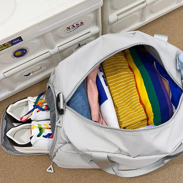 Open nylon duffle bag interior with mesh pocket and colorful packing items