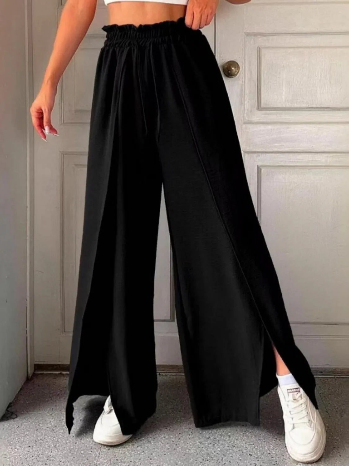 Black wide-leg slit pants with elastic waistband, flowing drape