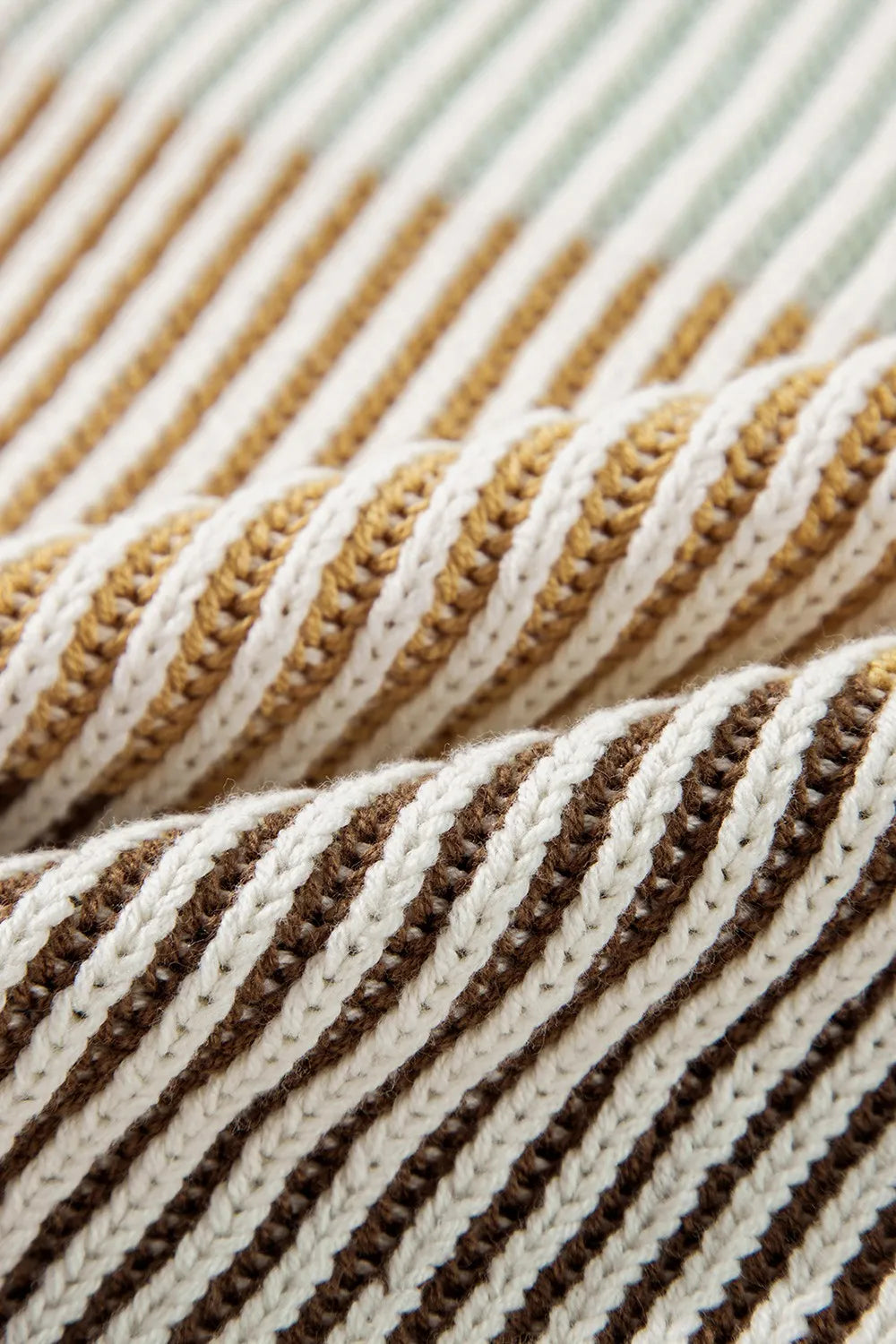 Knit fabric close-up of color-block striped sweater in cream, tan, and dark brown